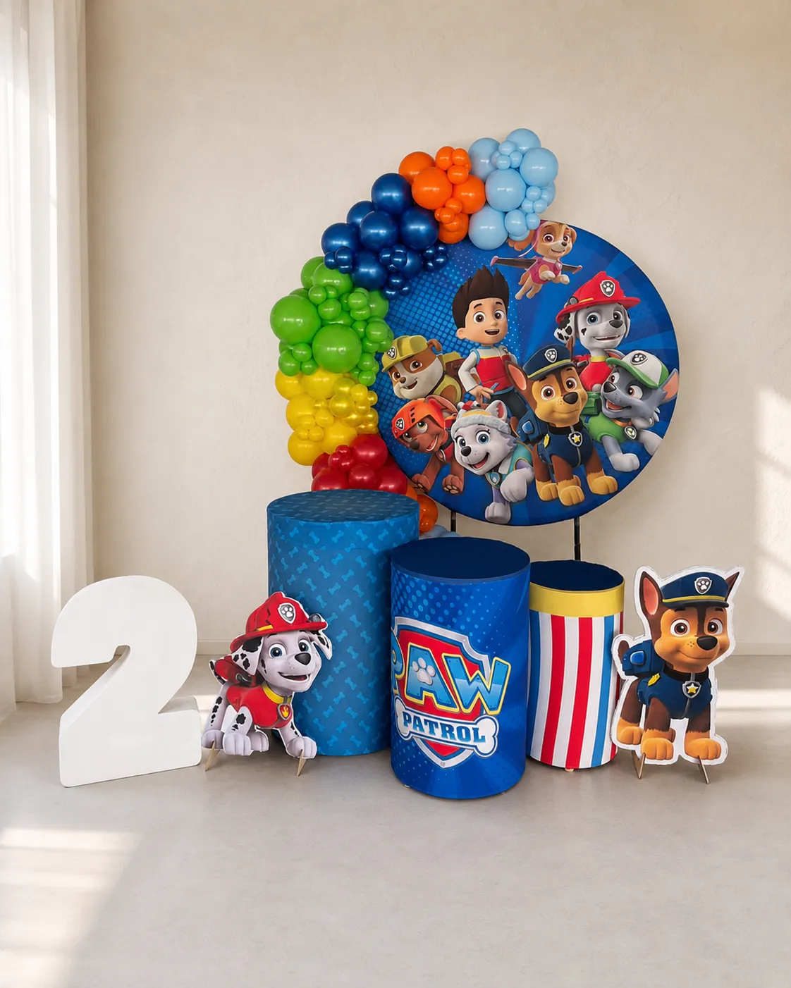 Escenografía infantil con arco de globos de colores y panel circular